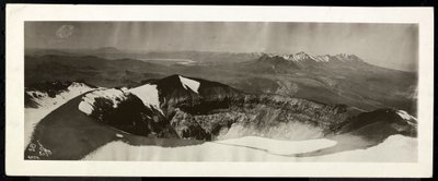 Panoramic view from above of a range of snowcapped mountains, and what appears to be the rim of a volcano, presumably on or near the Panama Canal, 1913 by Byron Company